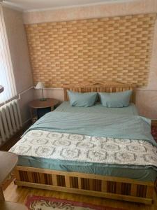 Popas Regal的一间卧室配有一张大床和木制床头板