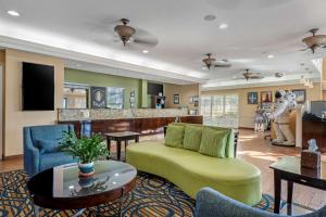 可可比奇可​​可海滩贝斯特韦斯特套房酒店的客厅配有绿色沙发和桌子
