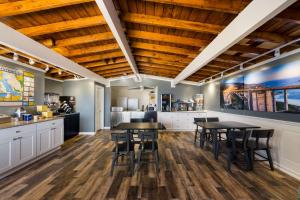 圣西米恩Pacific Coast Roadhouse Hotel的厨房设有木制天花板和桌椅。