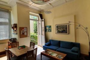 德累斯顿Ferienwohnungen Villa Haniel Carl的客厅配有蓝色的沙发和桌子