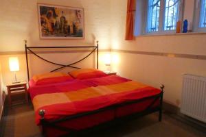 德累斯顿Ferienwohnung Villa Haniel Oskar的一间卧室配有一张带红色和黄色毯子的床