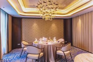 上海上海扬子江丽笙精选酒店的一间带桌椅和吊灯的用餐室