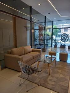圣米格尔·德·图库玛Jade Barrio Sur A Estrenar by Citrino Aparts的带沙发和玻璃桌的客厅