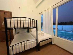 夜功府The PaVillu de Pool Villas的卧室设有两张双层床,位于窗户旁
