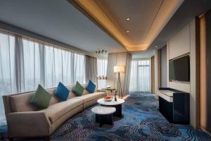 上海上海虹桥绿地铂瑞酒店的带沙发和电视的客厅
