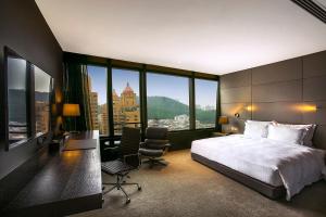 深圳深圳乐酒店的酒店客房,配有一张床、一张桌子和椅子