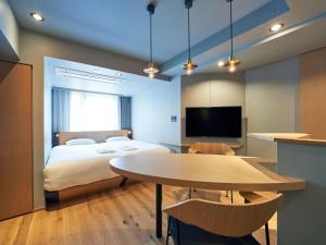 东京COCOSHUKU AKASAKA Premium的一间卧室配有一张床、一张桌子和一台电视。