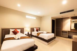 Ban KhaekPranee Home Phang-nga的酒店客房设有两张床和电视。