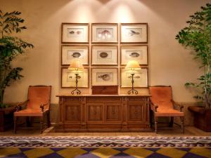 读谷村阿利维亚日光酒店的一间设有两把椅子和一张桌子及两盏灯的房间