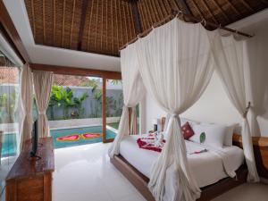 金巴兰Avery Le Nixsun Villas Uluwatu by Waringin Hospitality的一间卧室设有天蓬床和游泳池