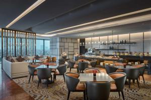 上海上海虹桥绿地铂瑞酒店的一间带桌椅的餐厅和一间酒吧