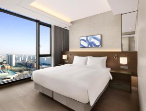 水原市Four Points by Sheraton Suwon的卧室设有一张白色大床和大窗户