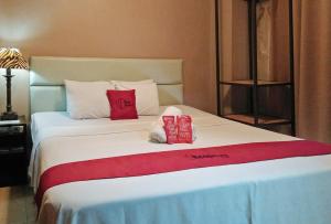 宿务RedDoorz Plus New Era Budget Hotel Mabolo former RedDoorz near Landers Superstore Cebu City的一间卧室配有一张带两个红色枕头的床