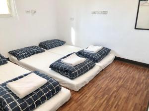 Hsi-kuo-shan不倒翁輕旅的一间设有四张床和枕头的客房