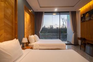 Liên Trì (4)Khách sạn gần biển Karina Phú Yên的酒店客房设有两张床和窗户。