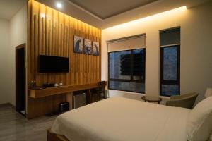 Liên Trì (4)Khách sạn gần biển Karina Phú Yên的一间卧室配有一张床和一台电视