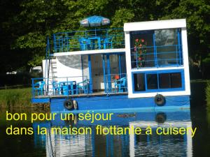 屈斯里Maison flottante sur la seille的水中一艘蓝色的船,上面写着“无溶剂”字样