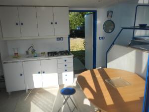 屈斯里Maison flottante sur la seille的厨房配有白色橱柜、桌子和用餐室。