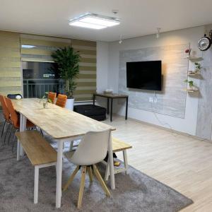 光州Sanwol Guesthouse的一间配备有桌椅和电视的会议室