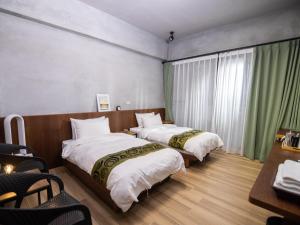 新城48-6民宿的酒店客房设有两张床和一张桌子。
