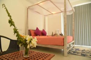 本托塔Eldezo Relax Paradise (Pvt) Ltd的一间卧室,配有一张带花瓶的桌子