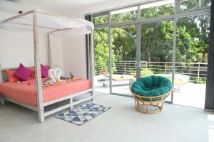 本托塔Eldezo Relax Paradise (Pvt) Ltd的一间卧室配有一张床、一把椅子和窗户。
