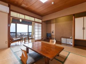 MurotoMisaki Kanko Hotel的客厅设有木桌和大窗户。