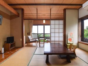 MurotoMisaki Kanko Hotel的客厅配有大型木桌和椅子