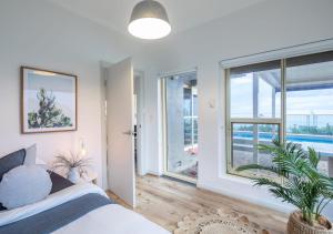 格莱内尔格Glenelg Beach House With Private Beachfront Pool的一间卧室设有一张床和一个大窗户