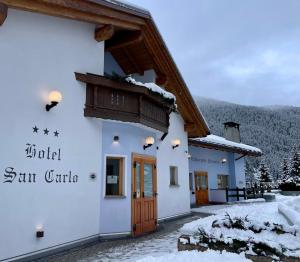 瓦尔迪登特罗Hotel San Carlo, tra Bormio e Livigno的山中一座积雪的建筑