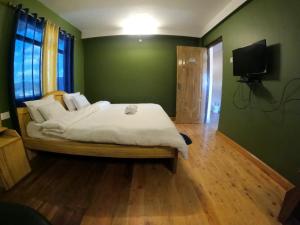 西隆AURORA GUEST HOUSE的卧室设有一张绿色墙壁上的白色大床