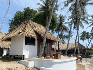 通萨拉Wild Wood x Hansa Beach Fitness Resort的棕榈树海滩上的小屋