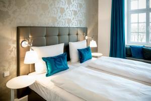 马格德堡马格德堡一号汽车旅馆的一间卧室配有一张带蓝色枕头的大床
