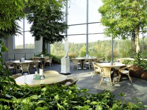 Lobbach曼弗雷德 - 绍尔基金会研讨会酒店的餐厅设有桌椅和大窗户。