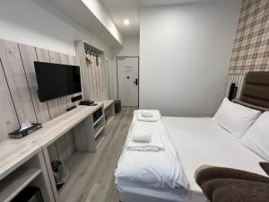 科隆Hotel Innception的小房间设有一张床和一台平面电视