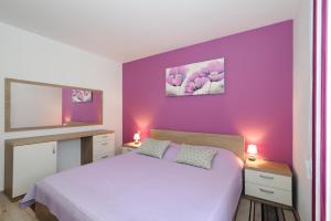 扎达尔Apartment Orlović Old Town的一间卧室设有紫色墙壁和一张床