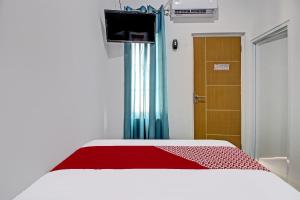 日惹Super OYO Collection O 92363 Kp Inn的一间卧室配有一张带红色毯子和门的床