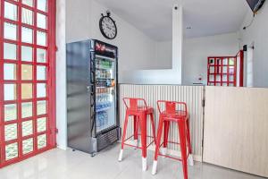 日惹Super OYO Collection O 92363 Kp Inn的厨房配有2张红色凳子和冰箱