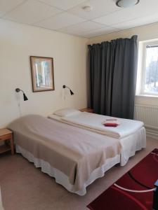本茨福什Hotell Hemgården的卧室配有一张大白色床和窗户
