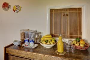 CarrigaholtGlencarrig B&B的厨房柜台,备有一碗水果和一瓶橙汁