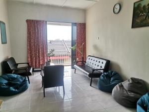 马六甲Eng Ban Hin guesthouse的带沙发和椅子的客厅以及大窗户。