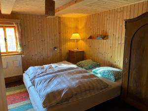 代斯纳Roubenka u potoka Jizerské hory的一间卧室配有一张床和一盏灯