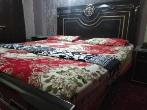拉合尔Kingston Motel的一张带红白毯子和枕头的床