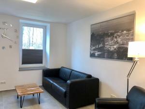 AhrensbökErdgeschoss-Appartement mit Seeterasse的客厅配有黑色沙发和桌子