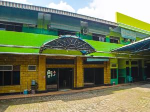 棉兰SPOT ON 92340 Lida Hotel的绿色和黄色的建筑