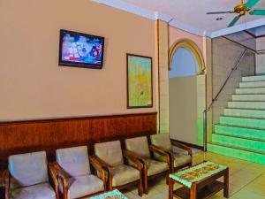 棉兰SPOT ON 92340 Lida Hotel的一间设有椅子和墙上电视的等候室