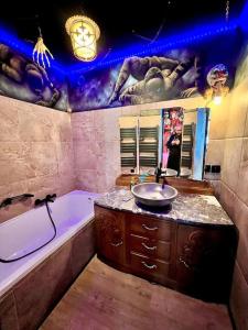 贝尔福Le Cirque Ensorcelé - Le Studio Maudit & Cosy的浴室配有盥洗盆、浴缸和浴缸。