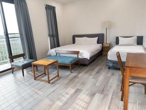 Zhongpu这里民宿的酒店客房带两张床和一张桌子以及椅子。