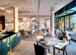 蒙特勒Royal Plaza Montreux的餐厅设有桌椅和窗户。