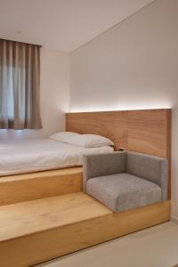 首尔Mangrove Sinseol的一间卧室配有一张床和一把椅子